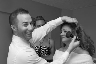 Stylist applying blush to bride